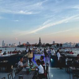 Jokiristeilylaivan kansi auringonlaskussa, taustalla Wat Arun